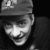 Bio pic of G Davis Cathcart. He wears a baseball cap and smiles up at us