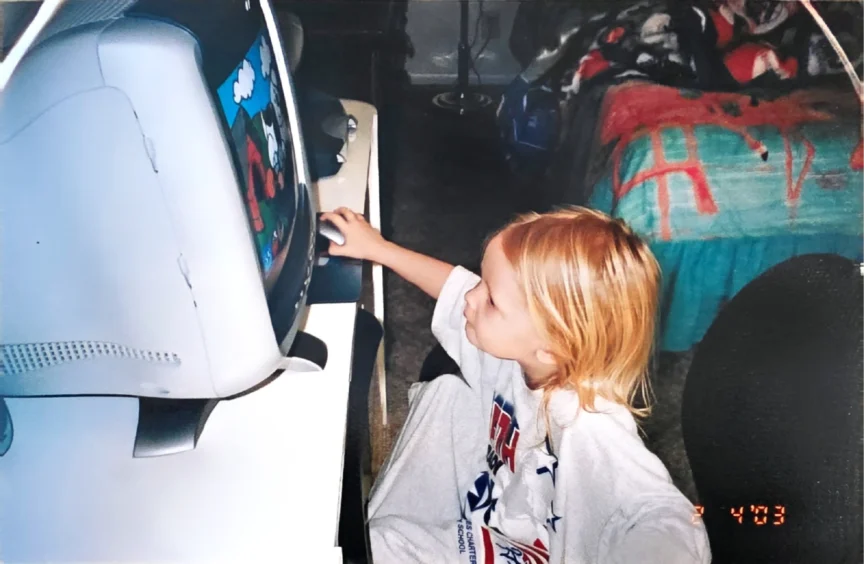 Photo of Katie Coleman as a baby using a computer from 2003.